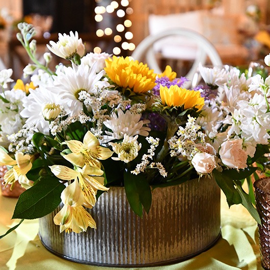 round tin with flower arrangement